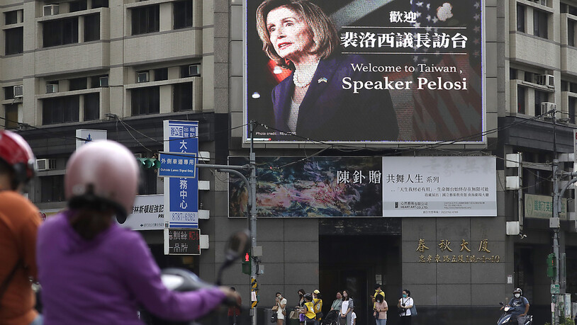 Menschen gehen an einem Plakat vorbei, das die Sprecherin des US-Repräsentantenhauses, Pelosi, in Taiwan willkommen heißt. Foto: Chiang Ying-Ying/AP/dpa
