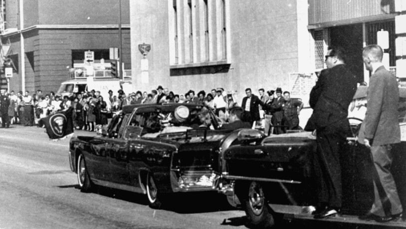 Die Präsidentenlimousine mit John Fitzgerald Kennedy und First Lady Jacqueline Kennedy sowie dem texanischen Gouverneur John Connally und seiner Frau wird von Geheimdienstleuten auf Trittbrettern verfolgt. Wenig später wurde Präsident John F. Kennedy von…