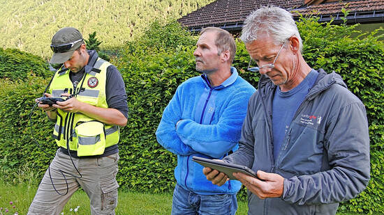 Hilfe aus der Luft: Markus Wigger (links, Leiter der Drohnenrettung) und Wildhüter Sämi Gantner überwachen zusammen mit einem Landwirt eine Drohnenrettung auf der Wiese des Landwirts. 