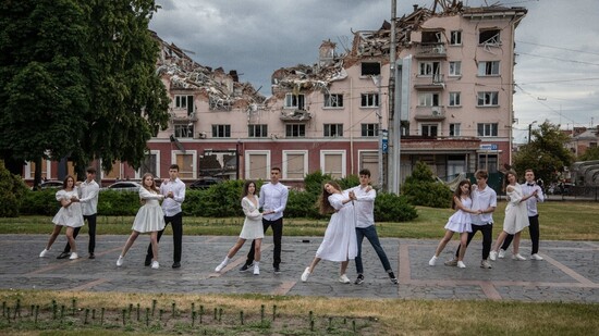 Surreal wirkt diese Aufnahme von Abiturienten der Schule Eins aus Tschernihiw, die vor einem zerstörten Hotel tanzen. Foto: Michal Burza/ZUMA Press Wire/dpa