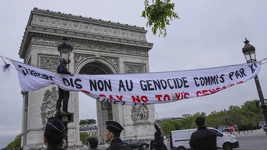 Polizeibeamte reißen ein Transparent herunter, das Aktivisten für ein freies Tibet aus Protest gegen den Besuch des chinesischen Präsidenten Xi Jinping in Frankreich neben dem Arc de Triomphe in Paris aufgehängt haben. Foto: Michel Euler/AP