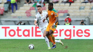 Algeriens Rami Bensebaini (l) kämpft gegen den Kapitän der Elfenbeinküste, um den Ball.