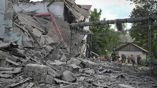 Rettungskräfte und Anwohner holen nach einem russischen Luftangriff eine Leiche aus den Trümmern eines Gebäudes. Foto: Efrem Lukatsky/AP/dpa