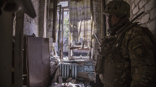 ARCHIV - Ein ukrainischer Soldat steht während schwerer Kämpfe an der Front in Sjewjerodonezk in der Region Luhansk in einer zerstörten Wohnung. Die Ukraine hat den Rückzug ihrer Truppen aus Sjewjerodonezk angeordnet. Das sagte der Gouverneur des Gebiets…
