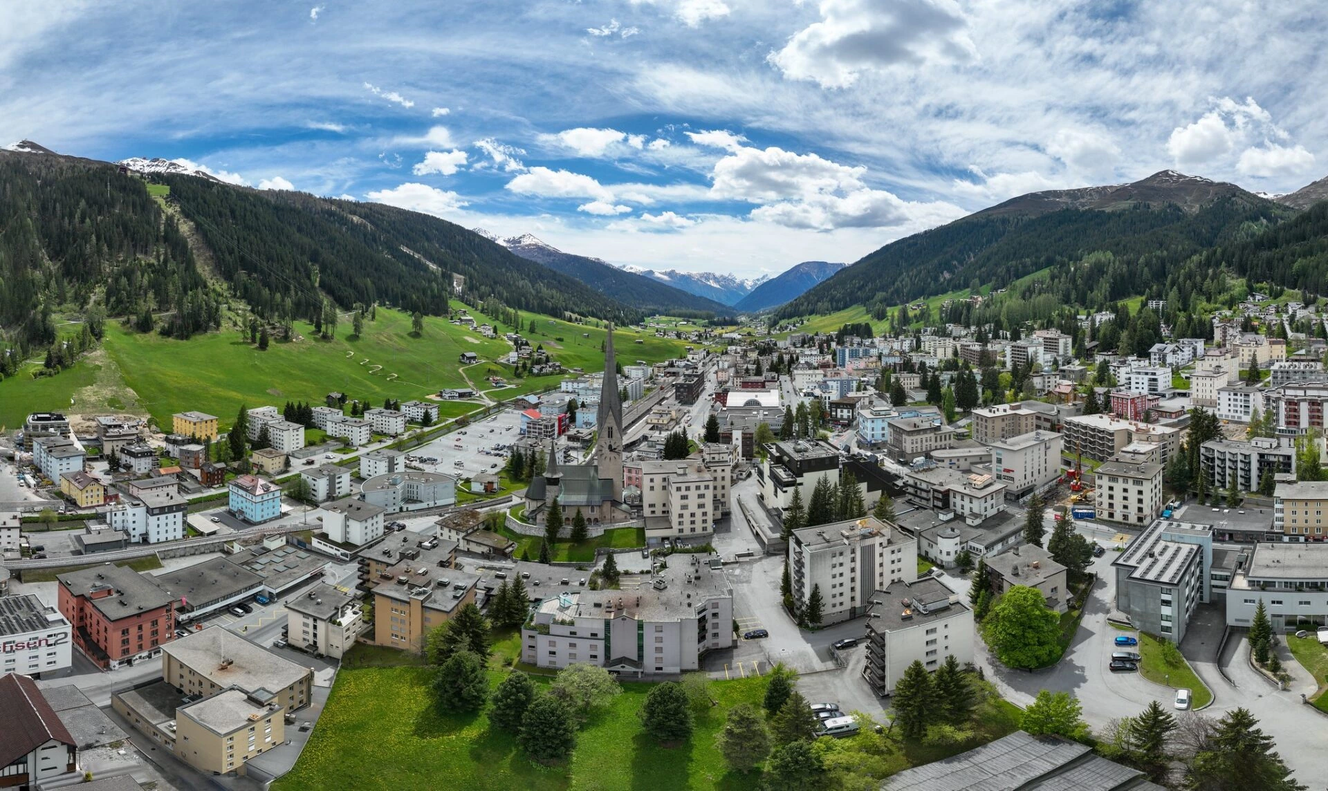 Davos Dorf in Graubünden mit alpinem Bergpanorama und grünen Wiesen im Sommer