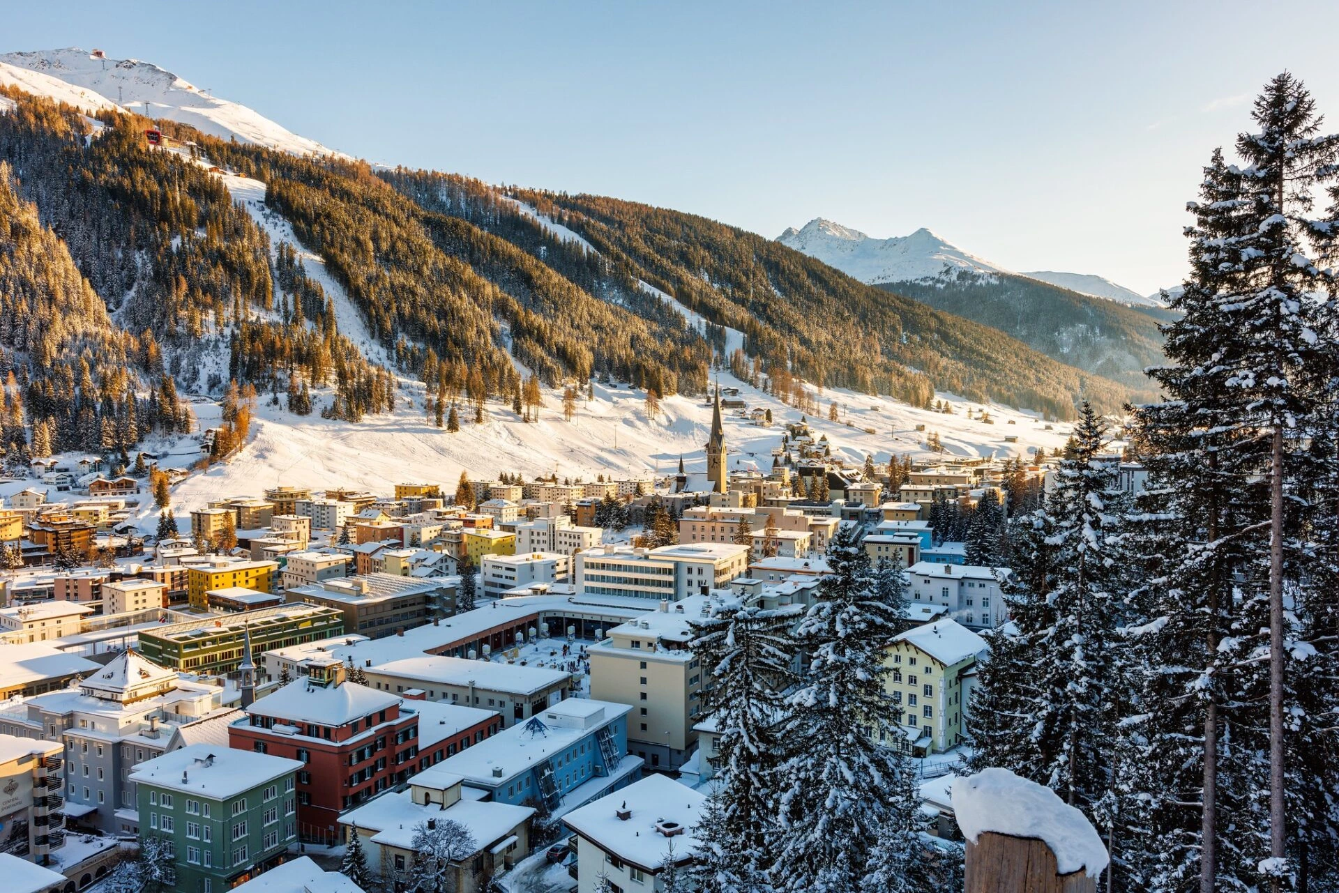 Verschneite Stadt Davos in Graubünden mit Blick auf Häuser und Alpen im Winter