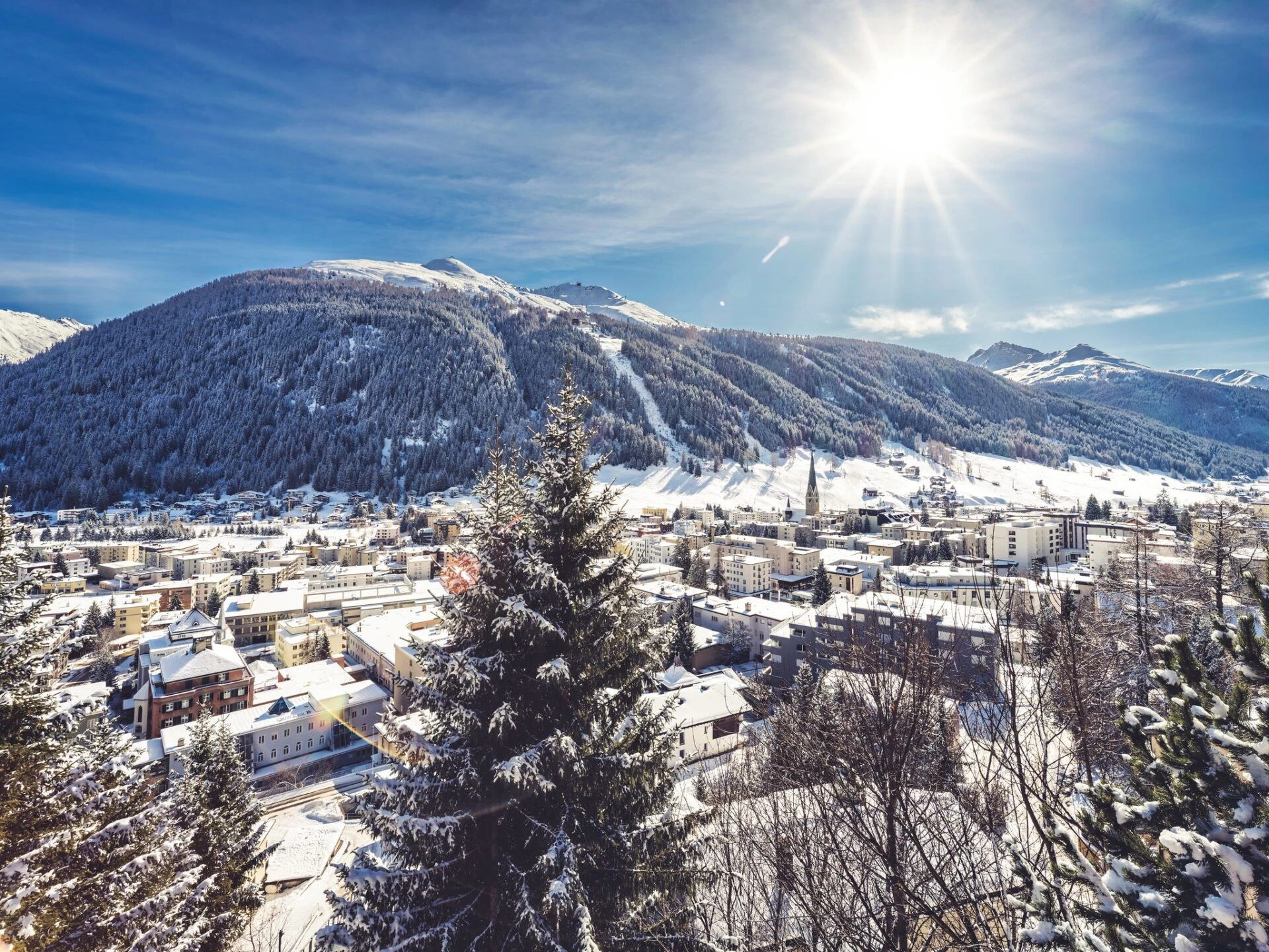 Sonnige Winterlandschaft in Davos mit verschneiten Bergen und alpinem Panorama